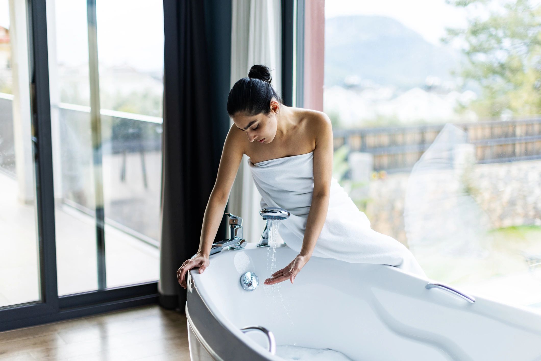 Woman preparing a relaxing bath at home